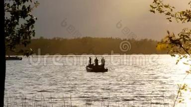 日落时分，渔民在湖边的摩托船上捕<strong>鱼</strong>的<strong>剪影</strong>。